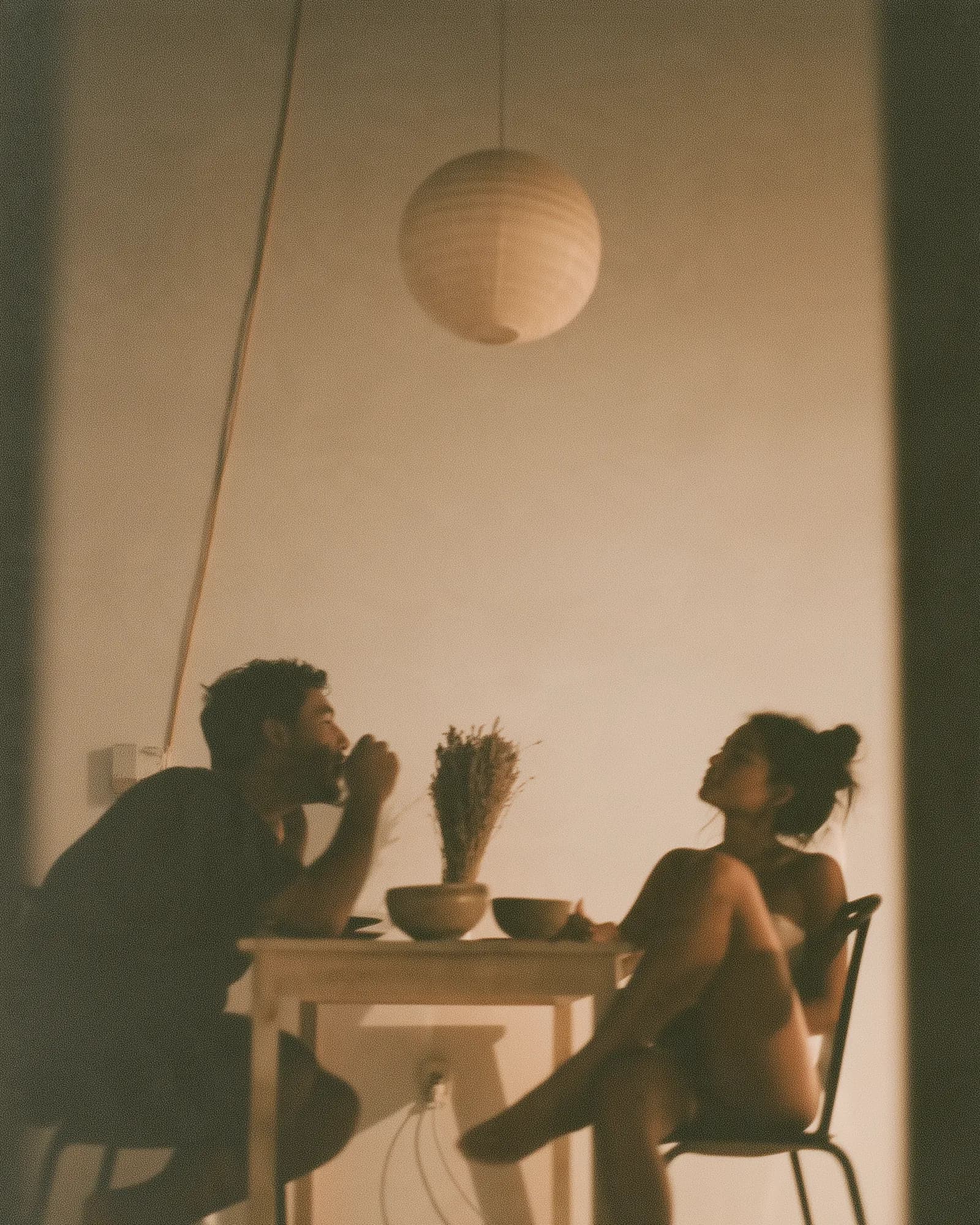 Two people at a small table under a paper lantern